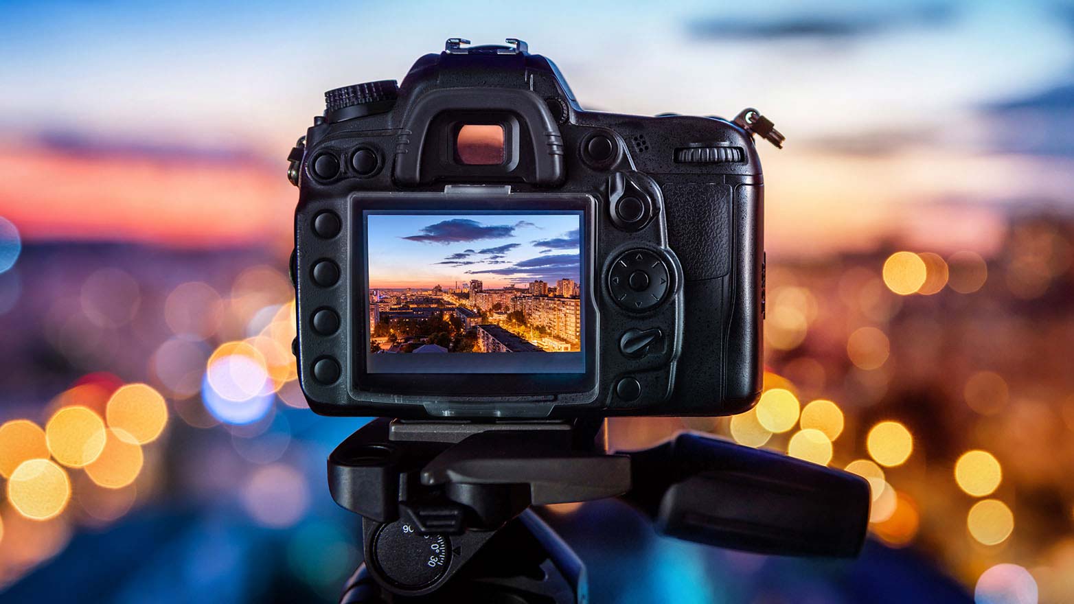camera on a tripod overlooking the city at night